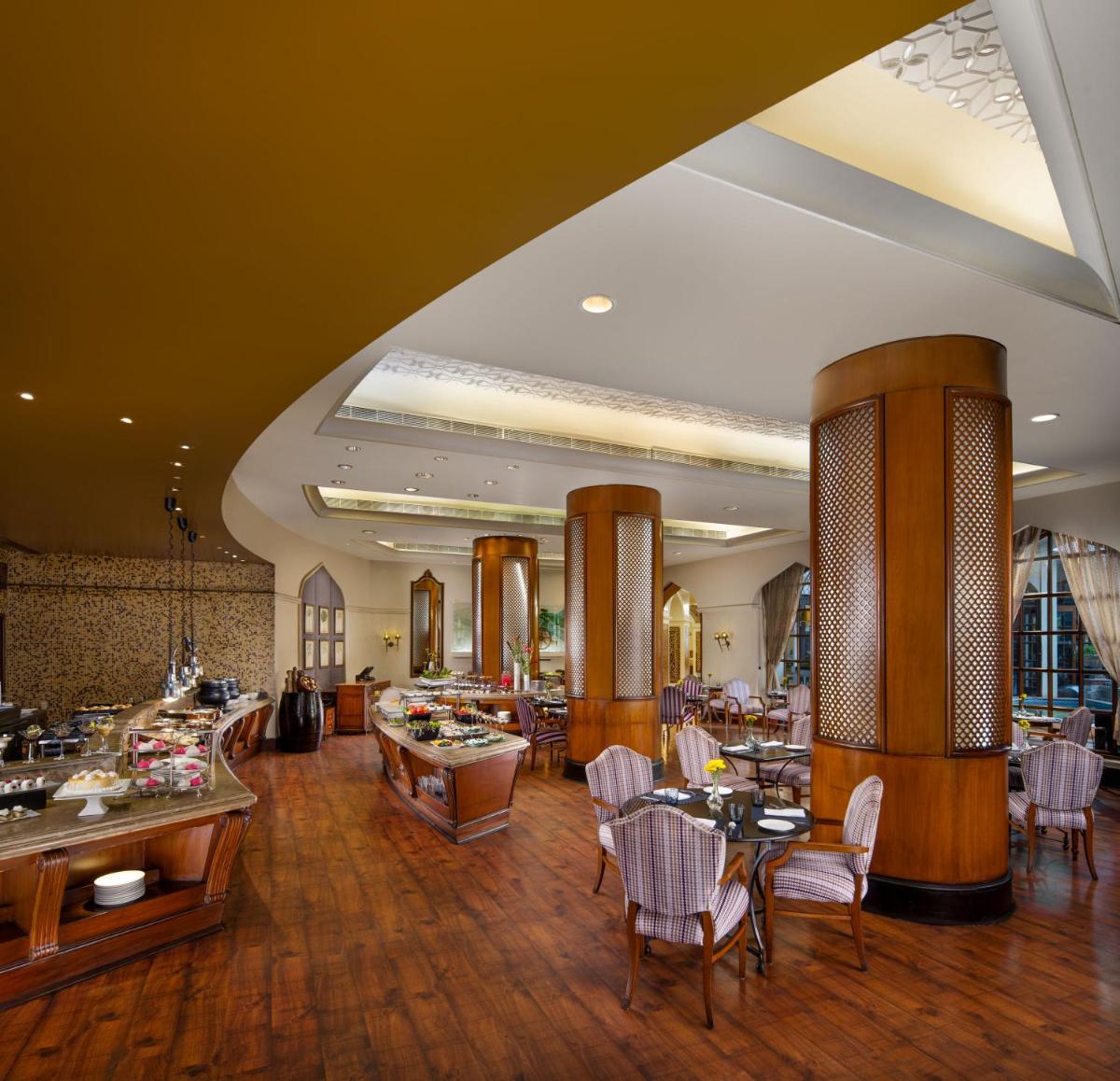 a lobby with tables and chairs and a restaurant at Taj Krishna in Hyderabad