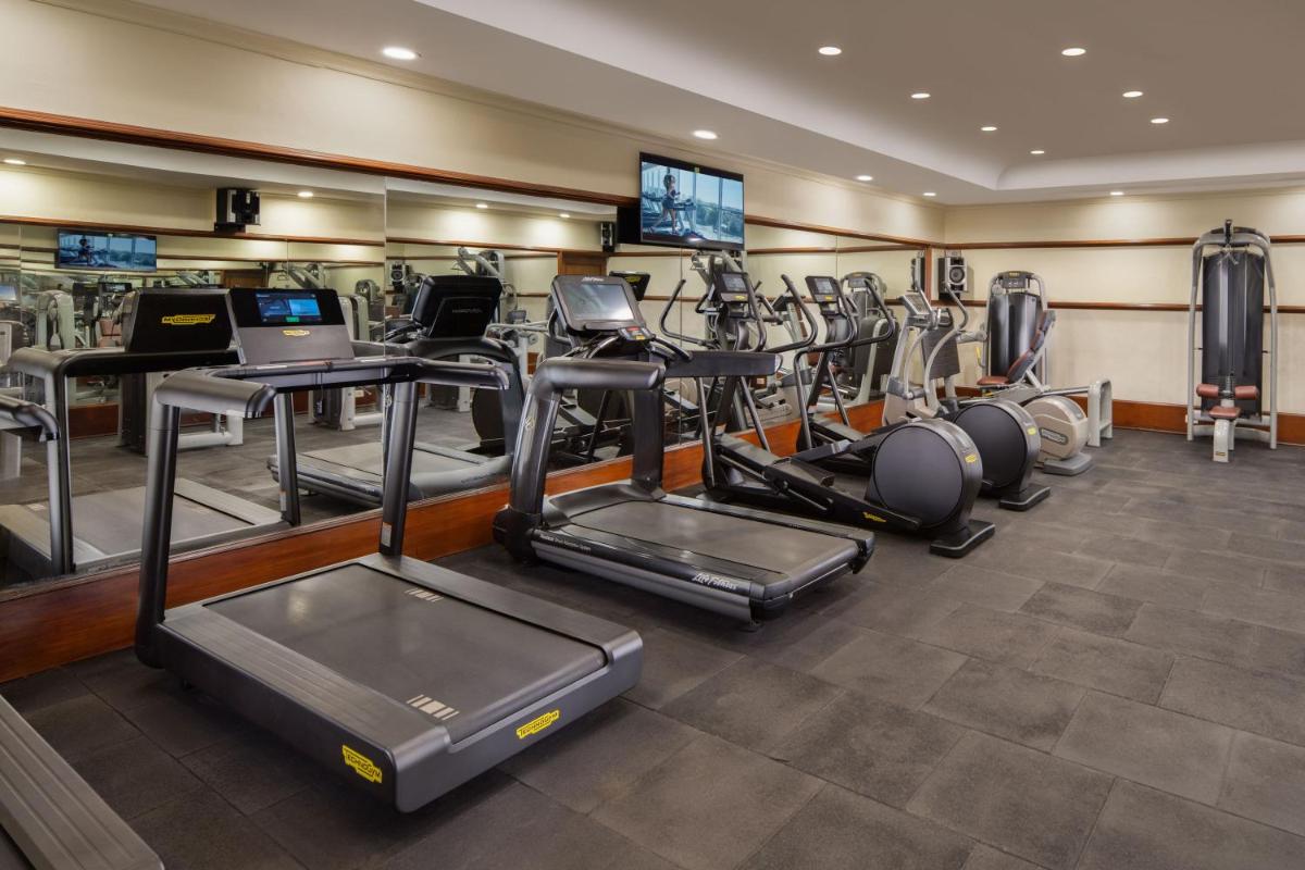 a gym with a bunch of treadmills and machines at Taj Krishna in Hyderabad