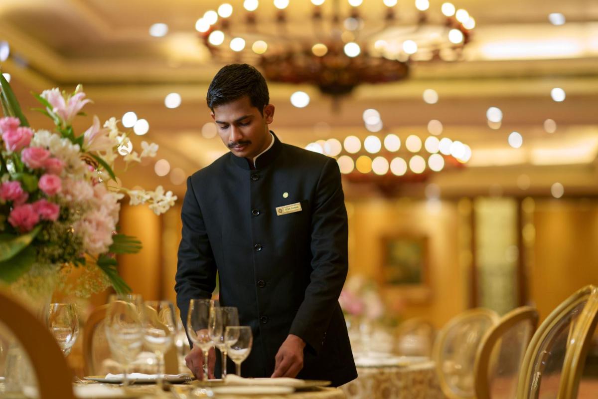 a man standing in front of a table with glasses at Taj Krishna in Hyderabad