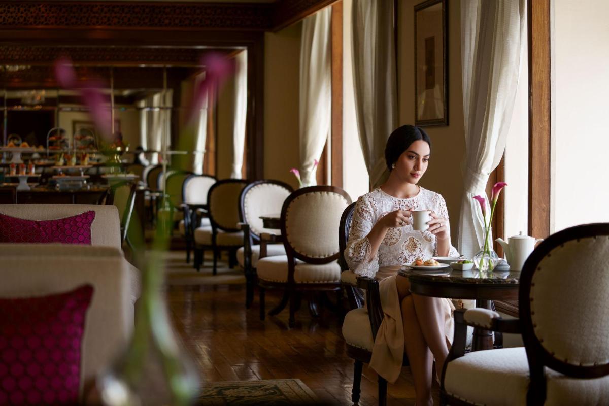a woman sitting at a table in a restaurant at Taj Krishna in Hyderabad