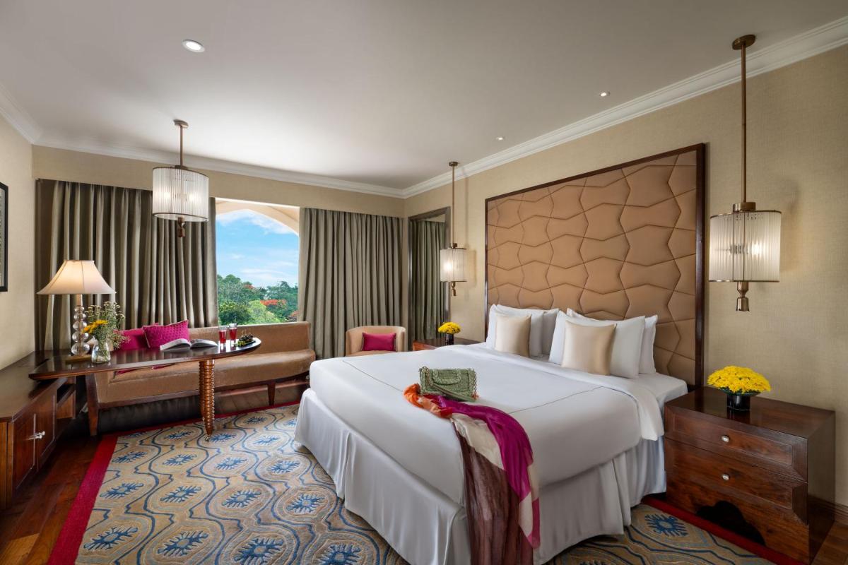 a hotel room with a large bed and a desk at Taj Krishna in Hyderabad