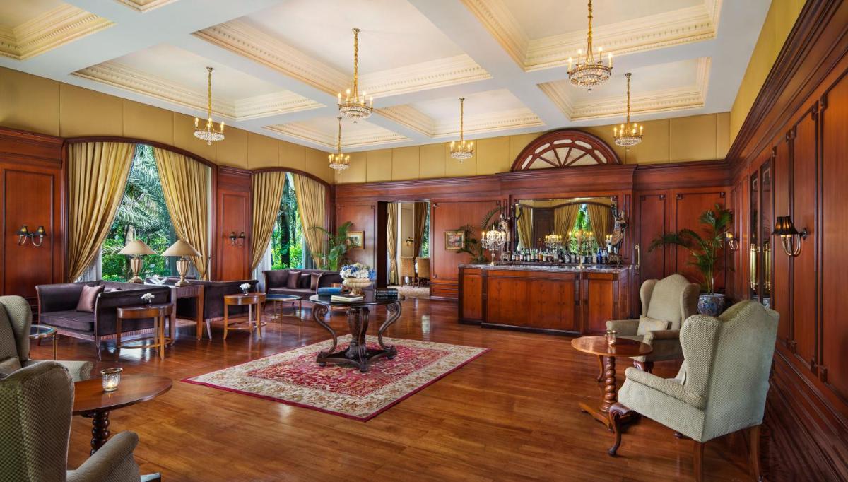 a living room with wood paneling and a table and chairs at Taj Krishna in Hyderabad