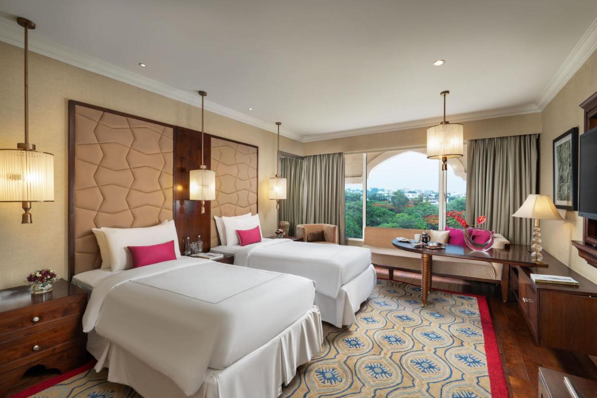 a hotel room with two beds and a window at Taj Krishna in Hyderabad