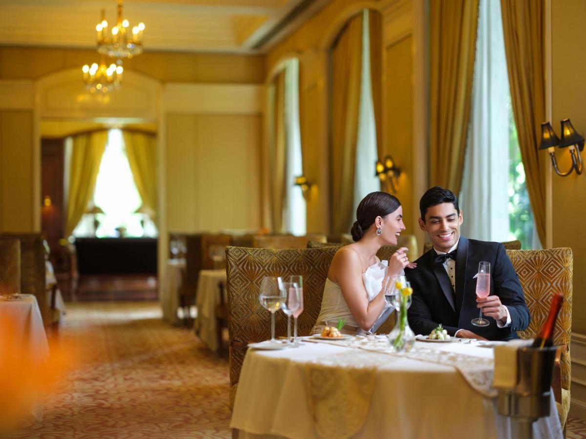 a bride and groom sitting at a table in a restaurant at Taj Krishna in Hyderabad