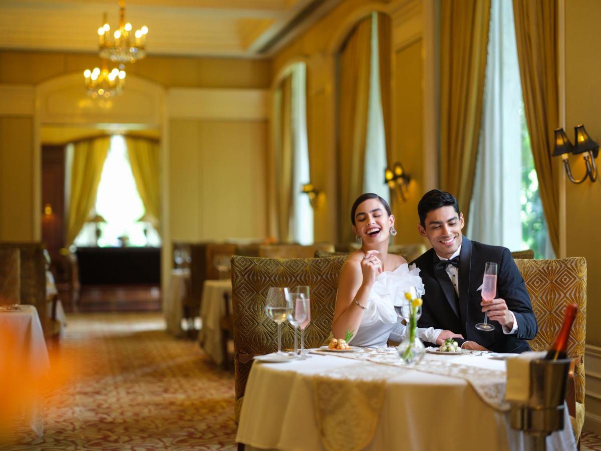 a bride and groom sitting at a table in a restaurant at Taj Krishna in Hyderabad