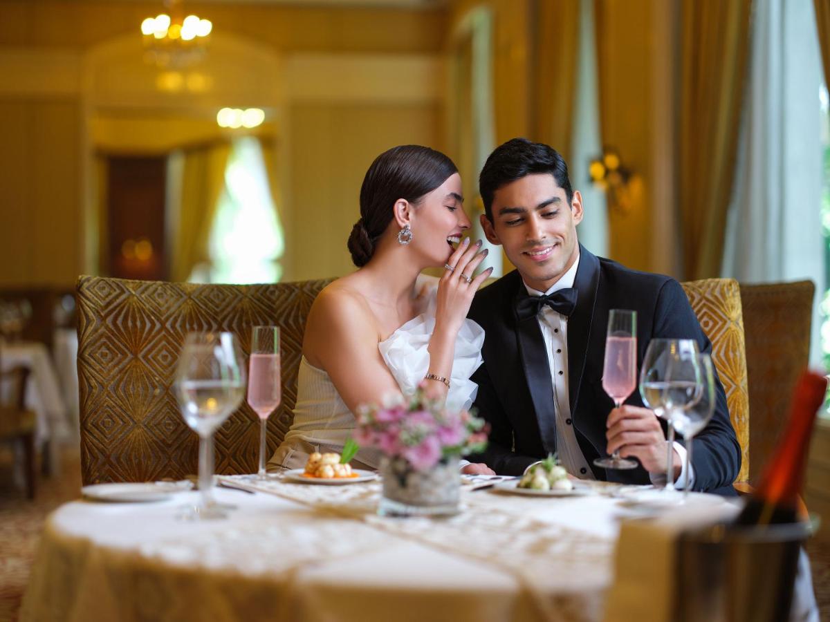 a bride and groom sitting at a table with wine glasses at Taj Krishna in Hyderabad