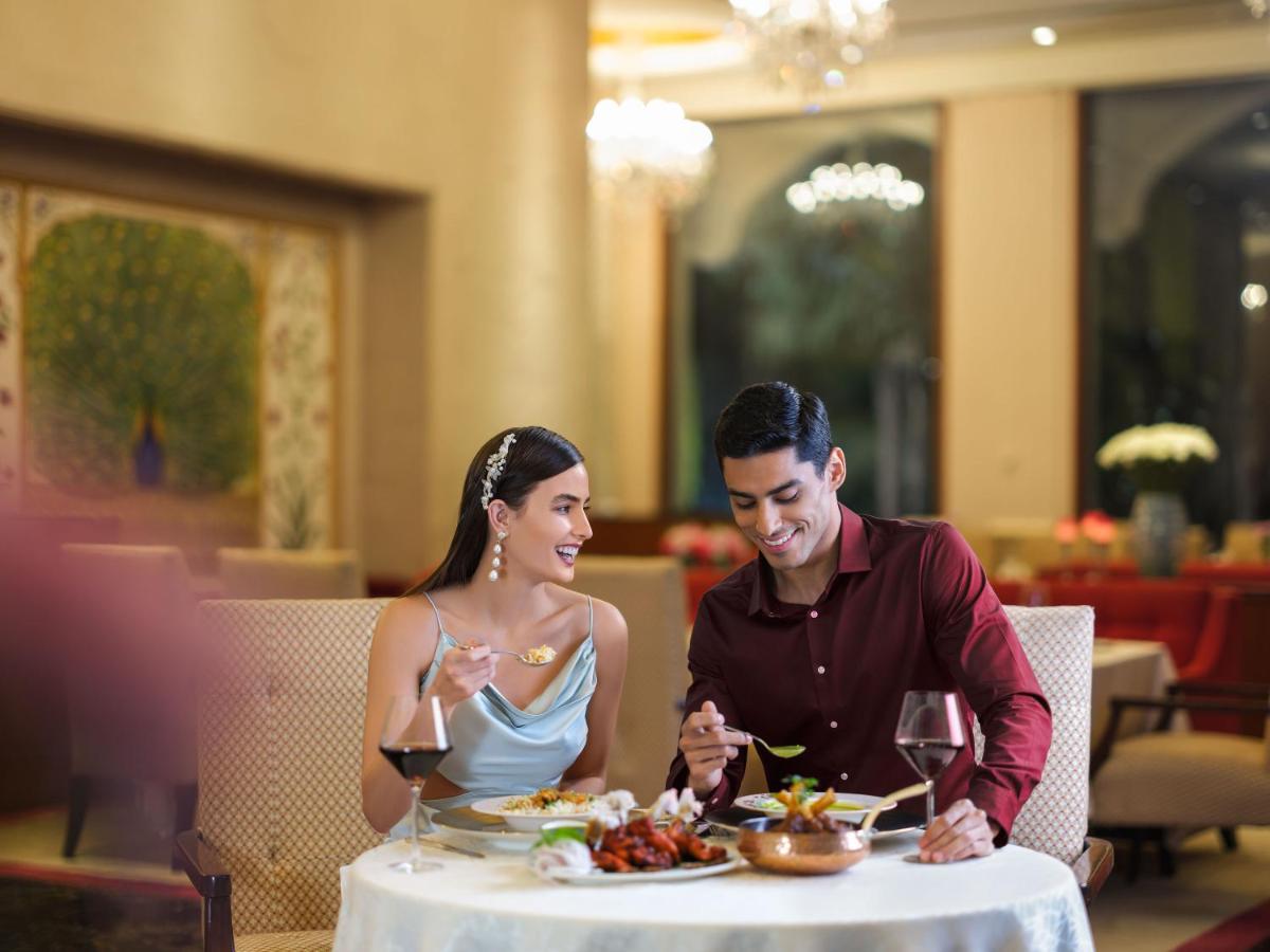 a man and a woman sitting at a table with food at Taj Krishna in Hyderabad