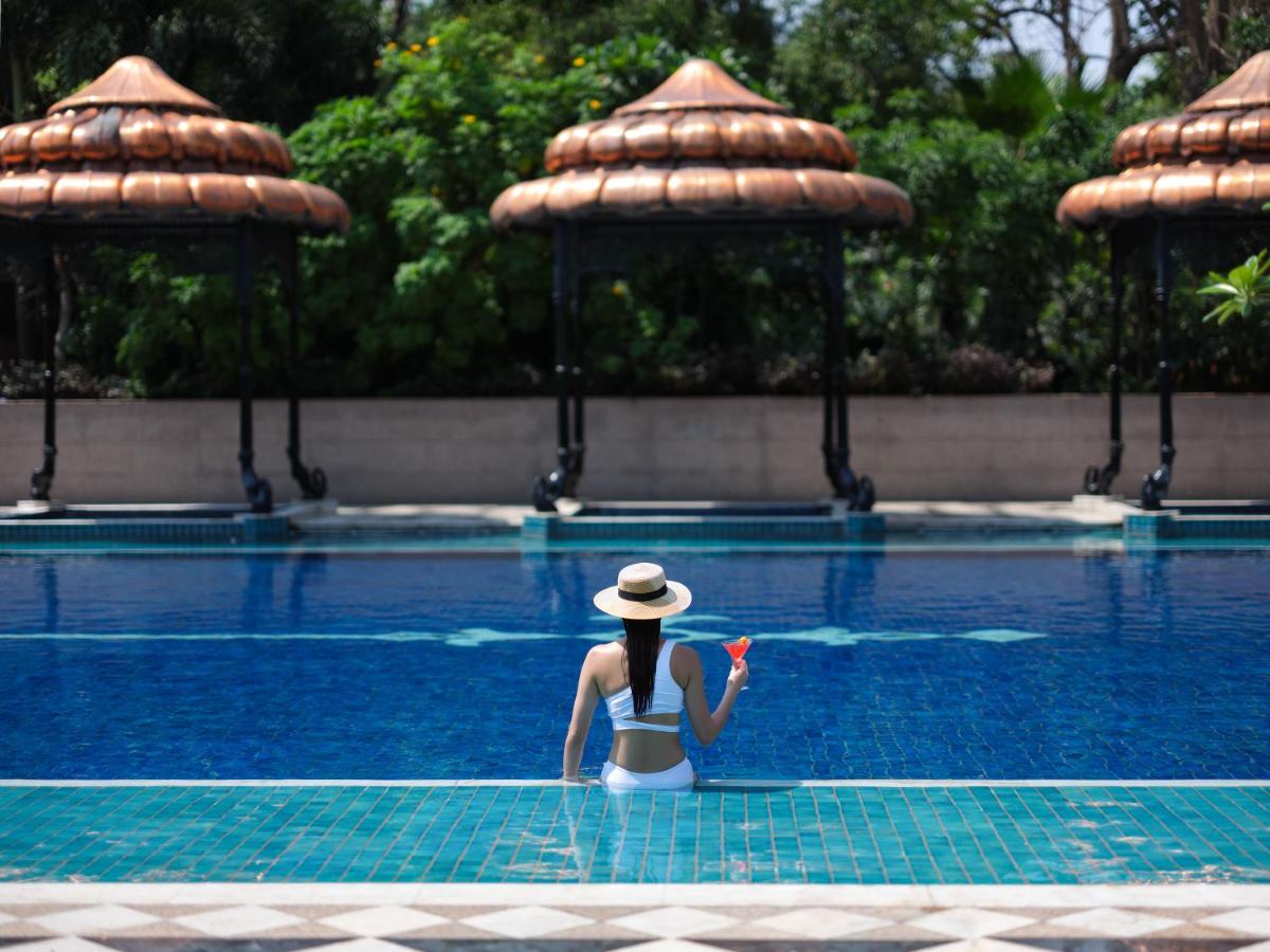 a woman in a hat sitting in a swimming pool at Taj Krishna in Hyderabad