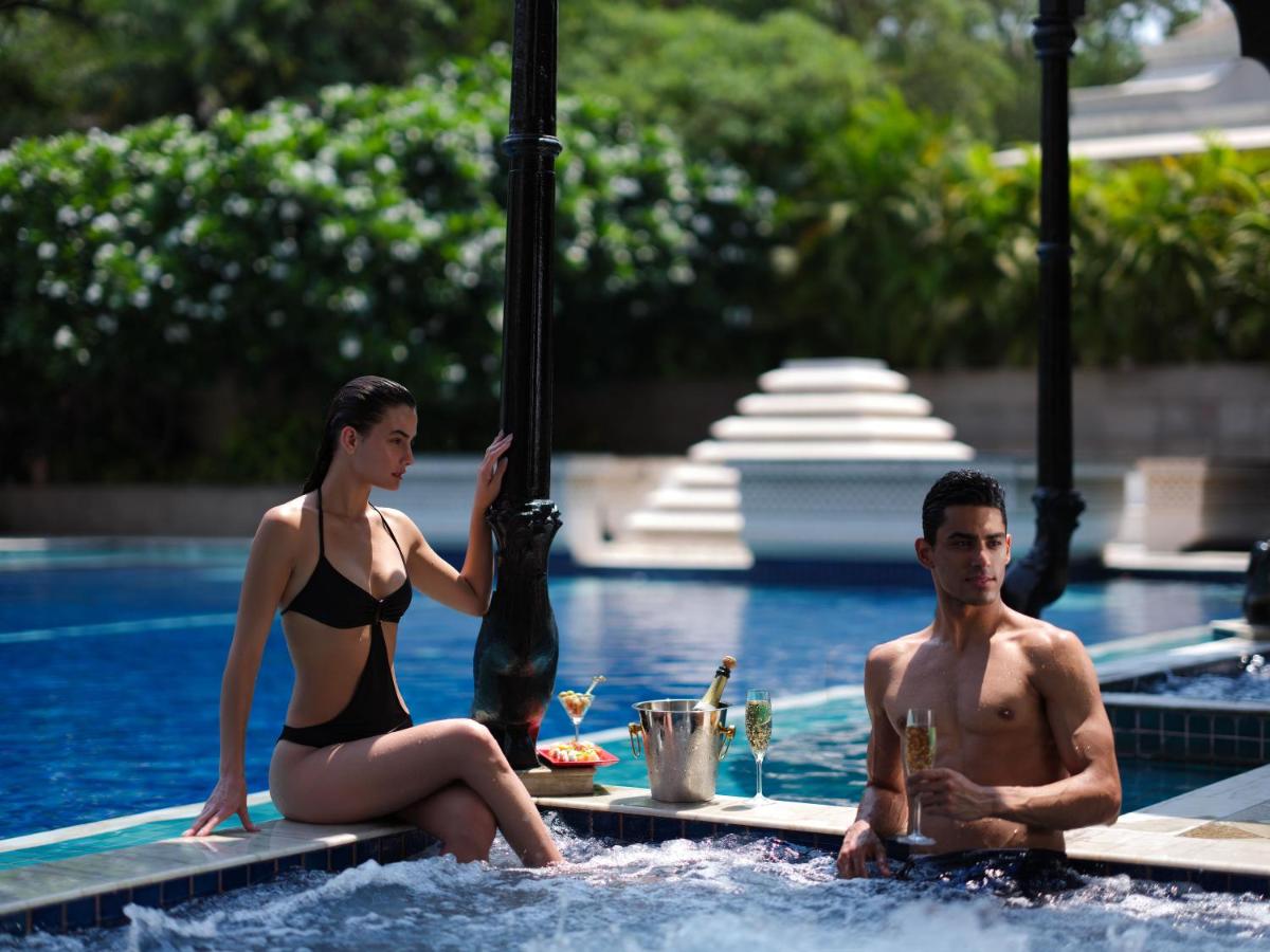 a man and a woman sitting in a swimming pool at Taj Krishna in Hyderabad