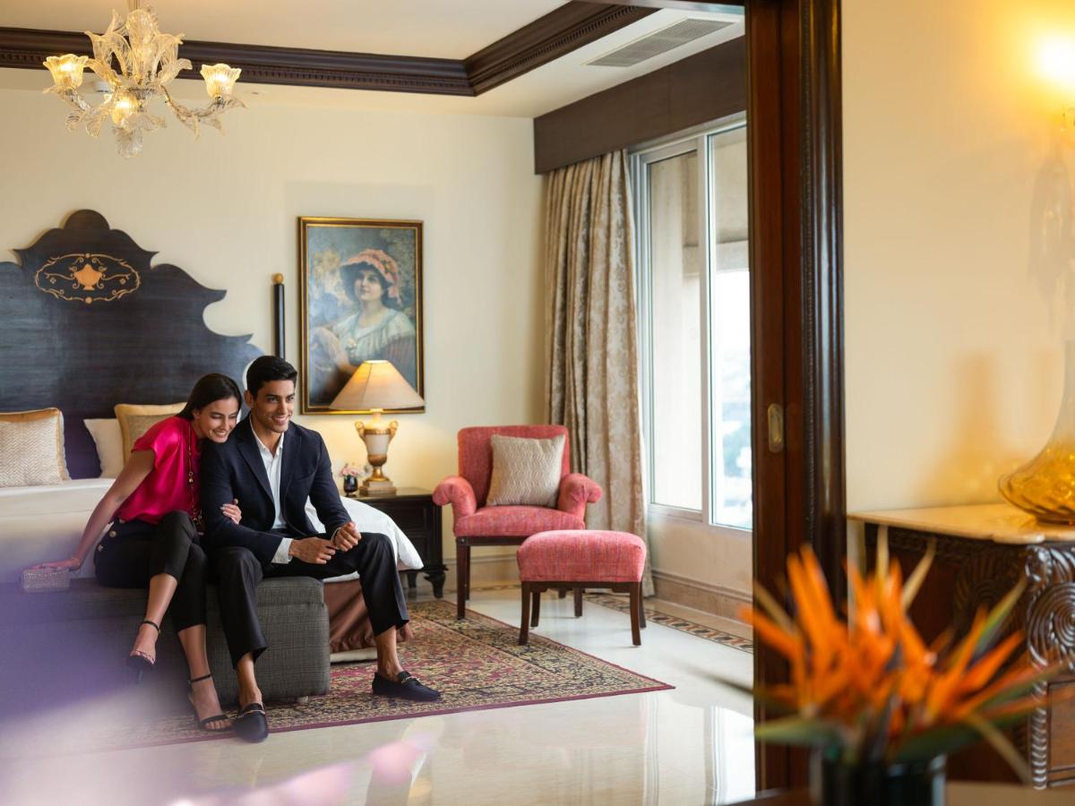 a man and a woman sitting on a bed in a hotel room at Taj Krishna in Hyderabad