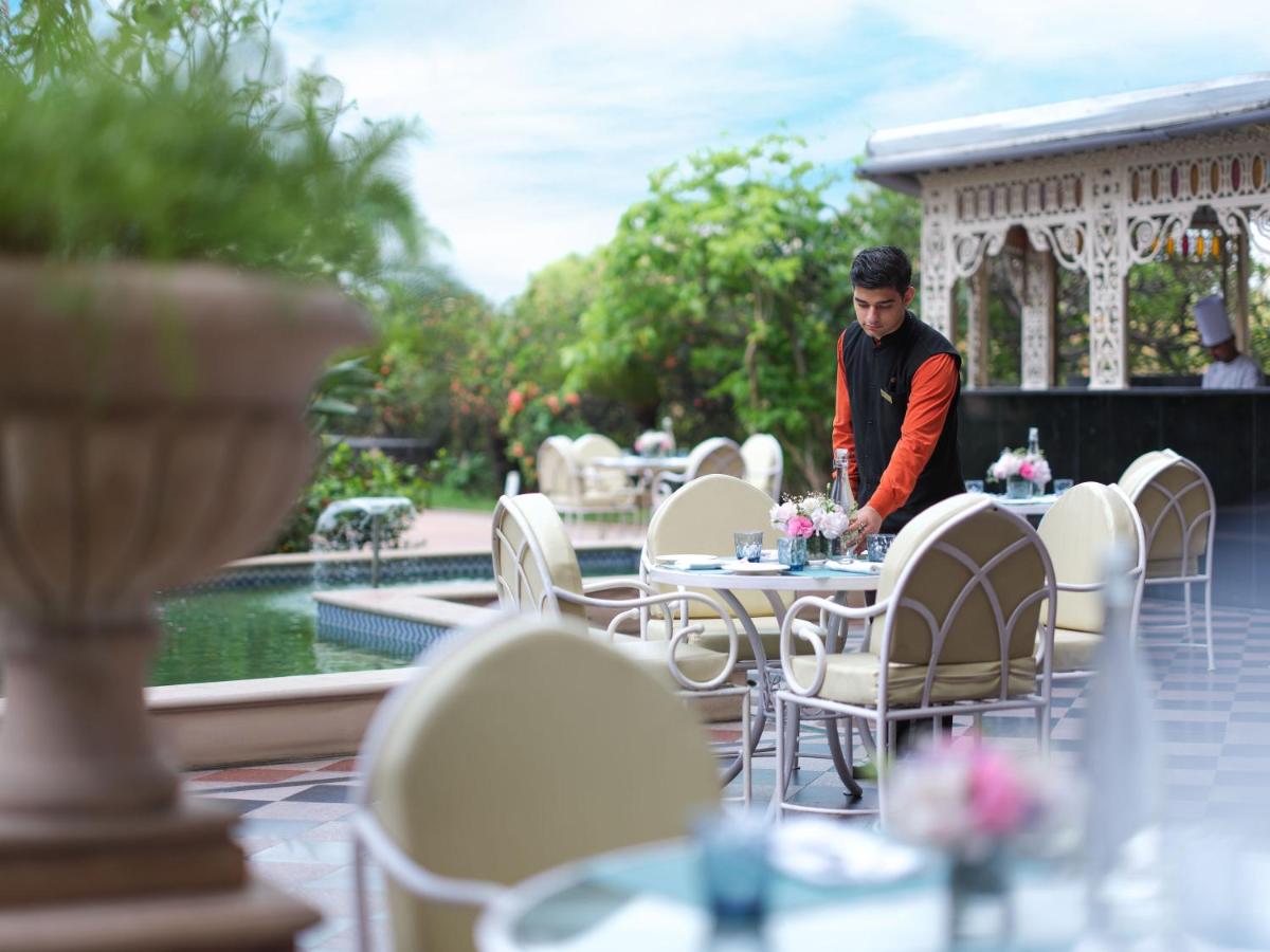 a man standing in front of a table with tables and chairs at Taj Krishna in Hyderabad