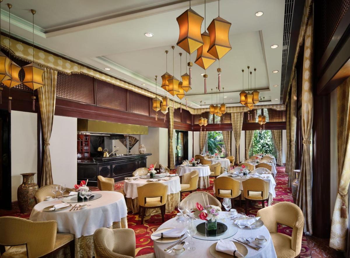 a dining room with white tables and chairs at Taj Krishna in Hyderabad