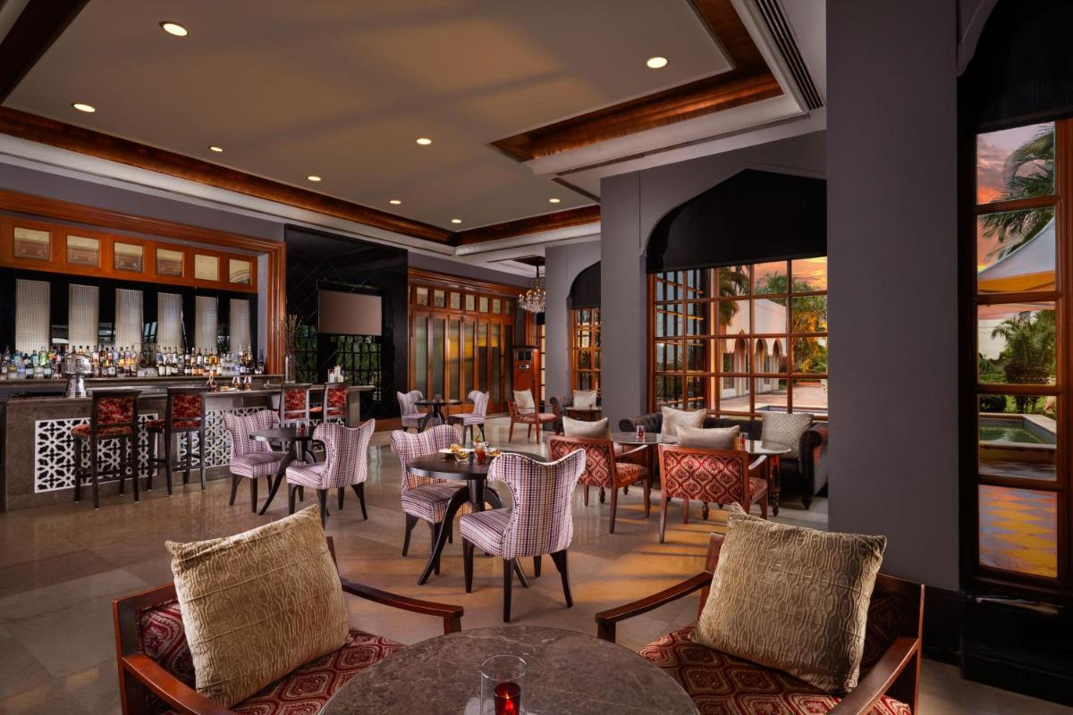 a restaurant with tables and chairs and a bar at Taj Krishna in Hyderabad
