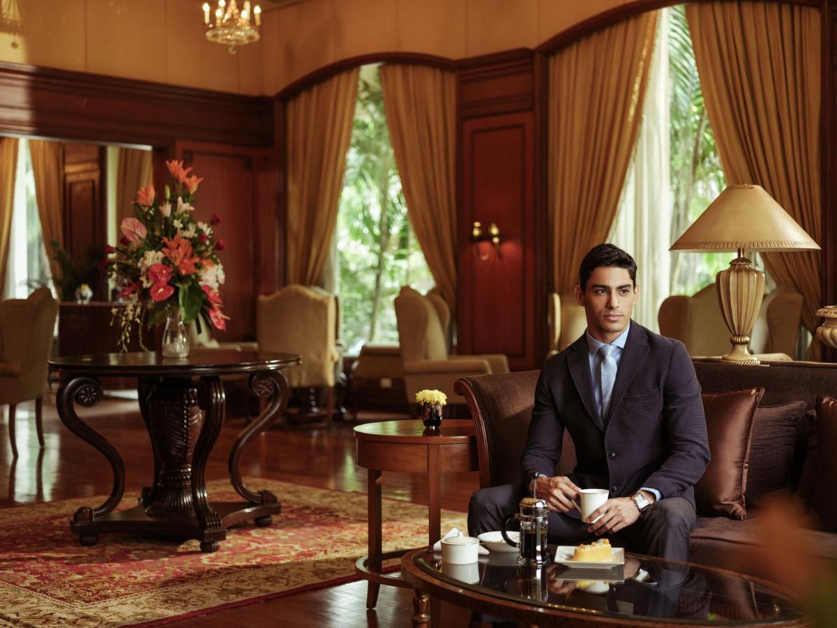 a man in a suit sitting in a living room at Taj Krishna in Hyderabad