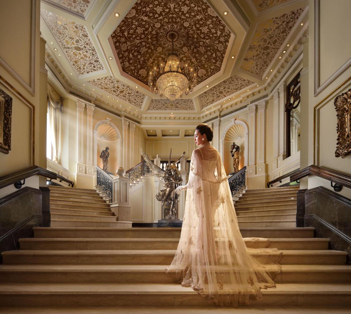 a woman in a wedding dress walking down the stairs at Taj Krishna in Hyderabad