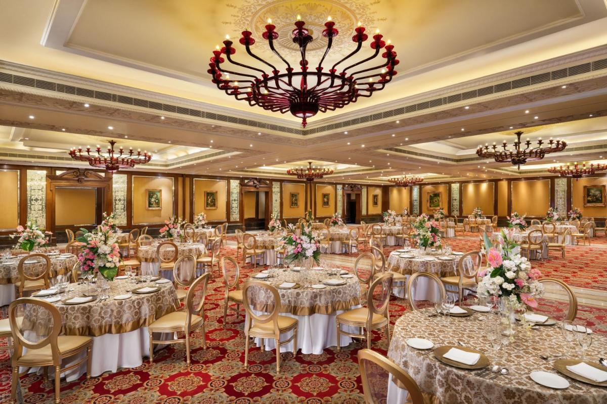 a banquet hall with tables and chairs and a chandelier at Taj Krishna in Hyderabad