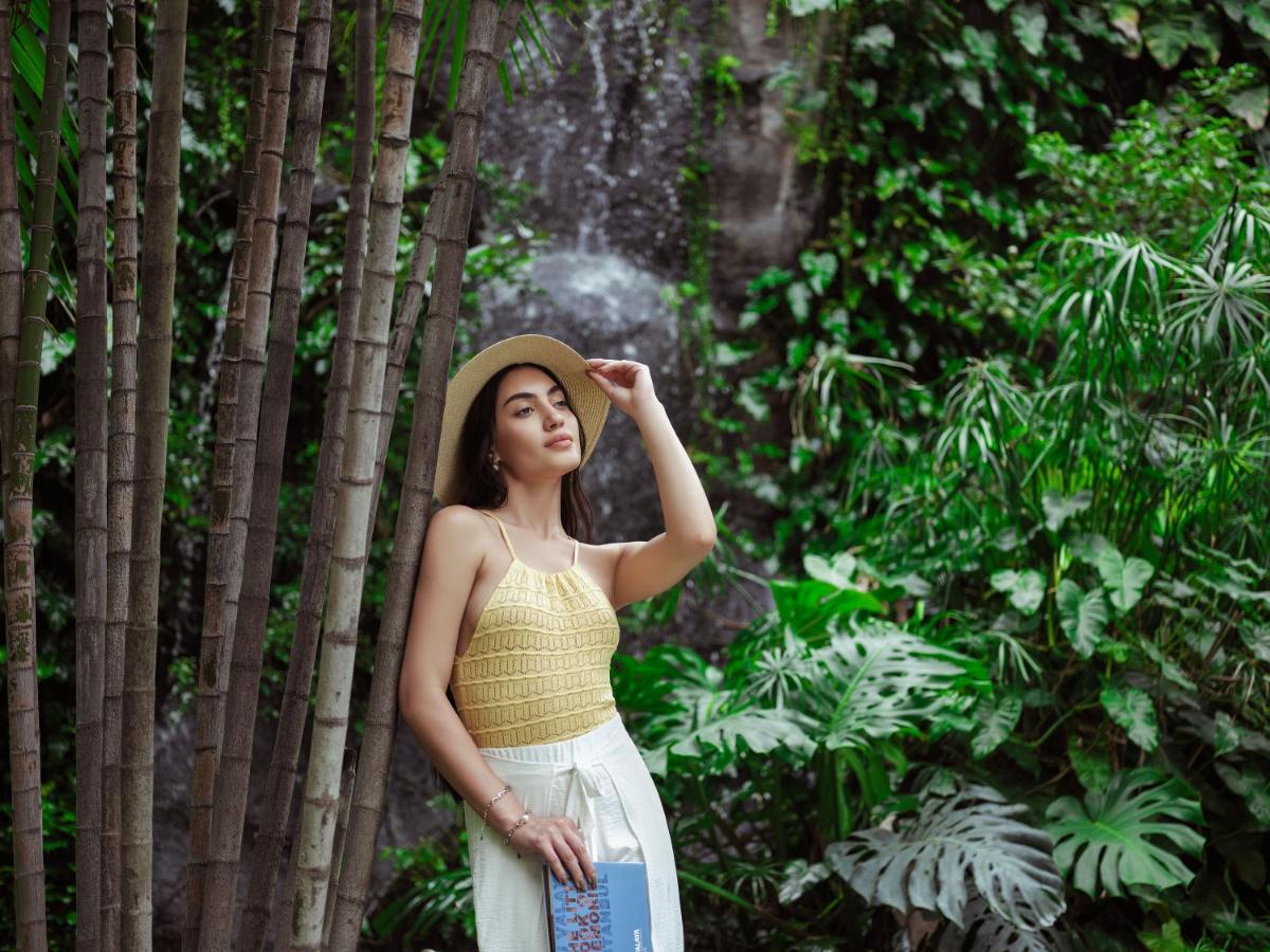 a woman wearing a hat standing in a forest at Taj Krishna in Hyderabad