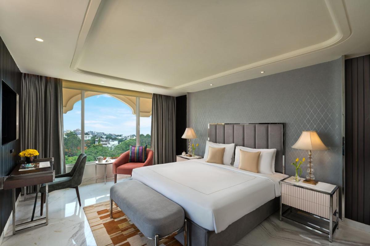 a bedroom with a large bed and a large window at Taj Krishna in Hyderabad