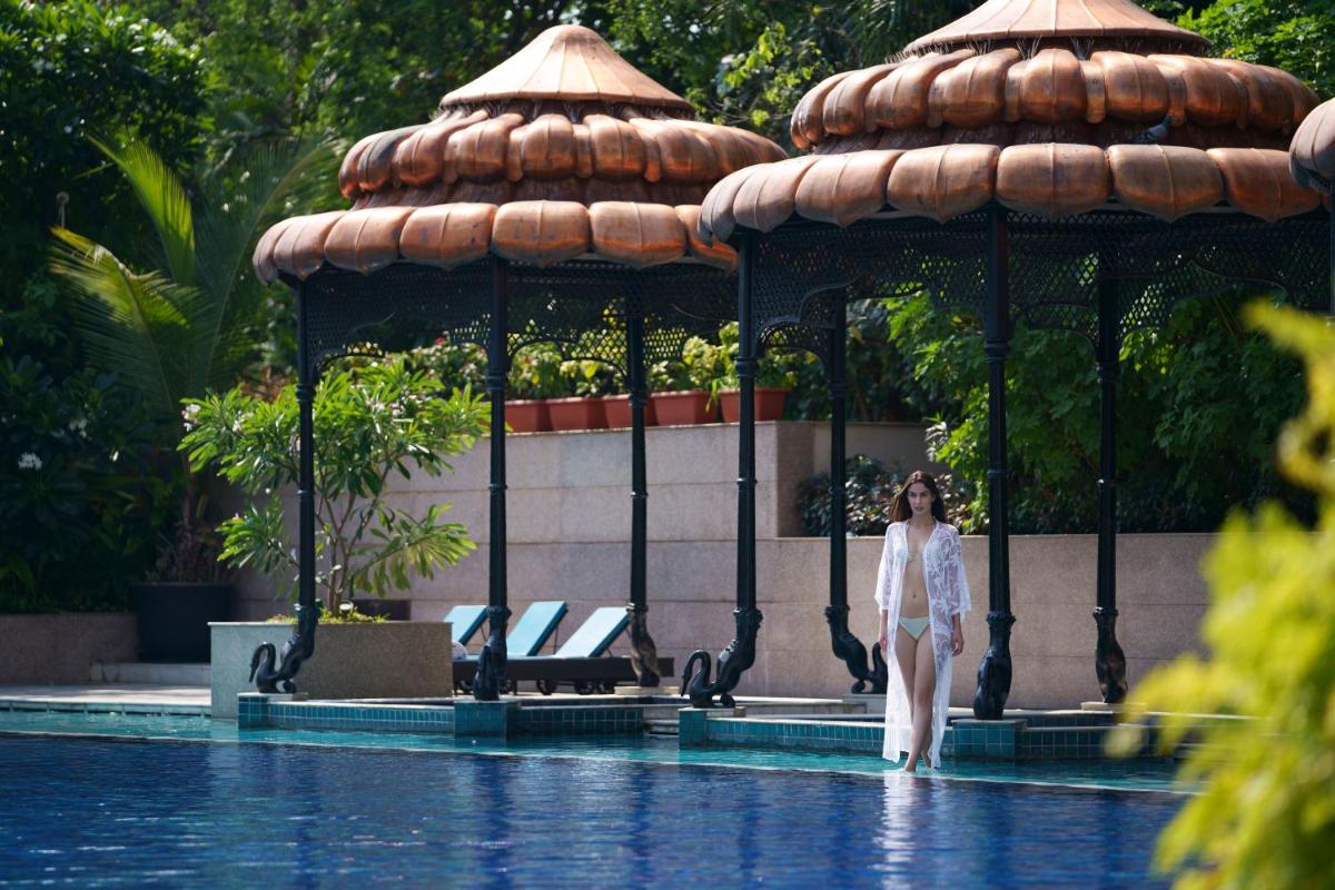 a woman standing in front of a gazebo by a pool at Taj Krishna in Hyderabad