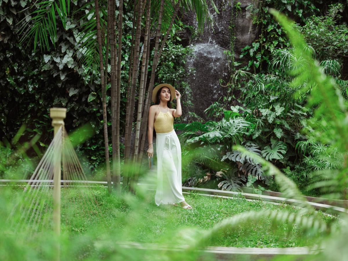 a woman standing in the forest talking on a cell phone at Taj Krishna in Hyderabad