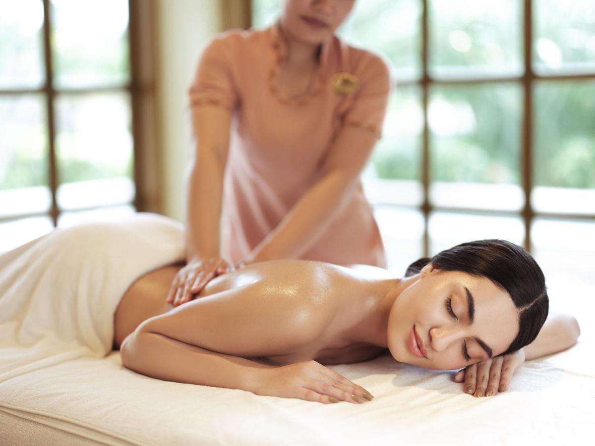 a woman laying on a bed getting a massage at Taj Krishna in Hyderabad