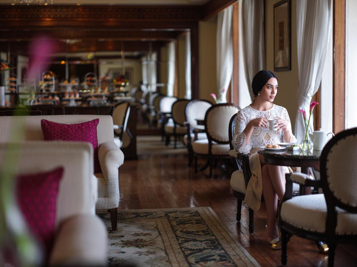 a woman sitting at a table in a restaurant at Taj Krishna in Hyderabad