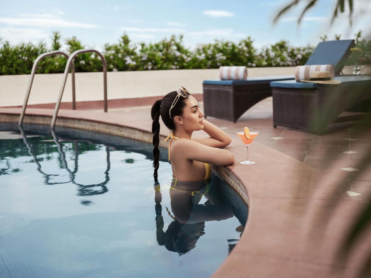 a woman is sitting in a swimming pool at Taj Krishna in Hyderabad