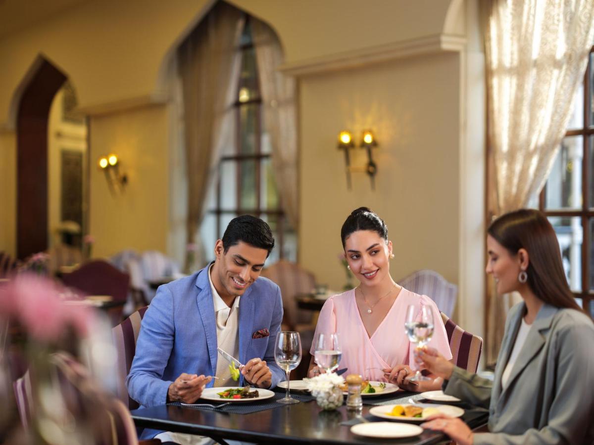 a man and woman sitting at a table in a restaurant at Taj Krishna in Hyderabad