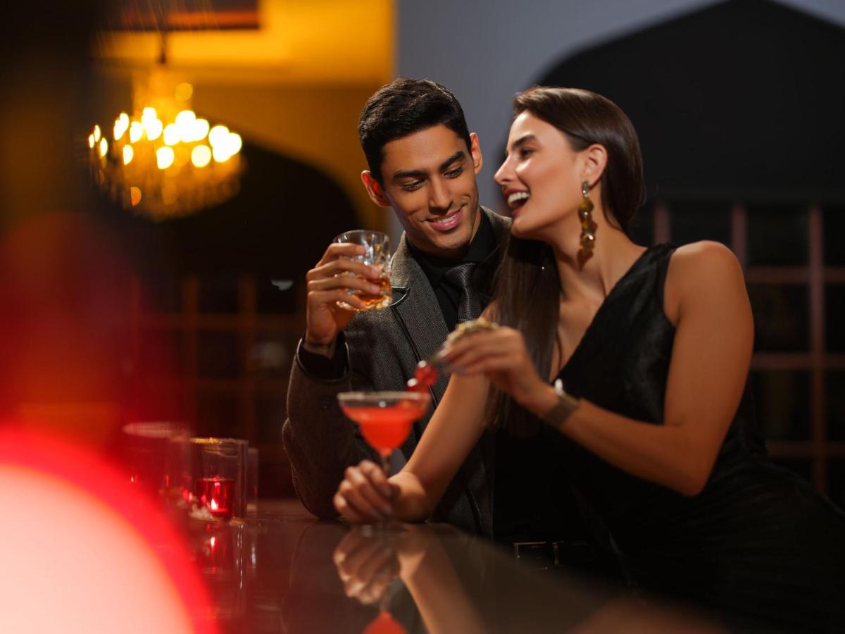 a man and a woman sitting at a table with wine glasses at Taj Krishna in Hyderabad