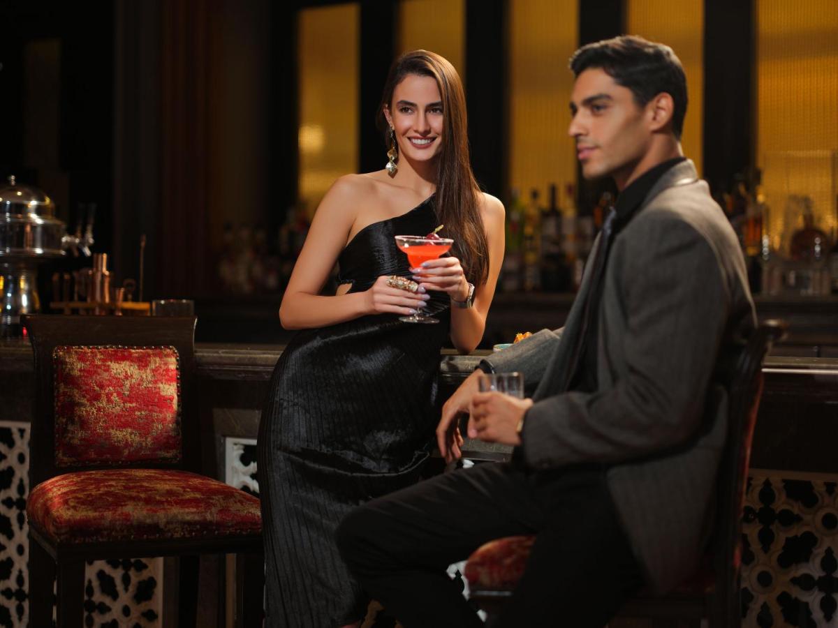 a woman in a black dress holding a drink at Taj Krishna in Hyderabad