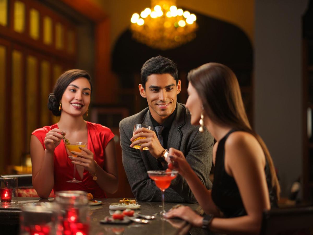 a group of people sitting at a table with drinks at Taj Krishna in Hyderabad