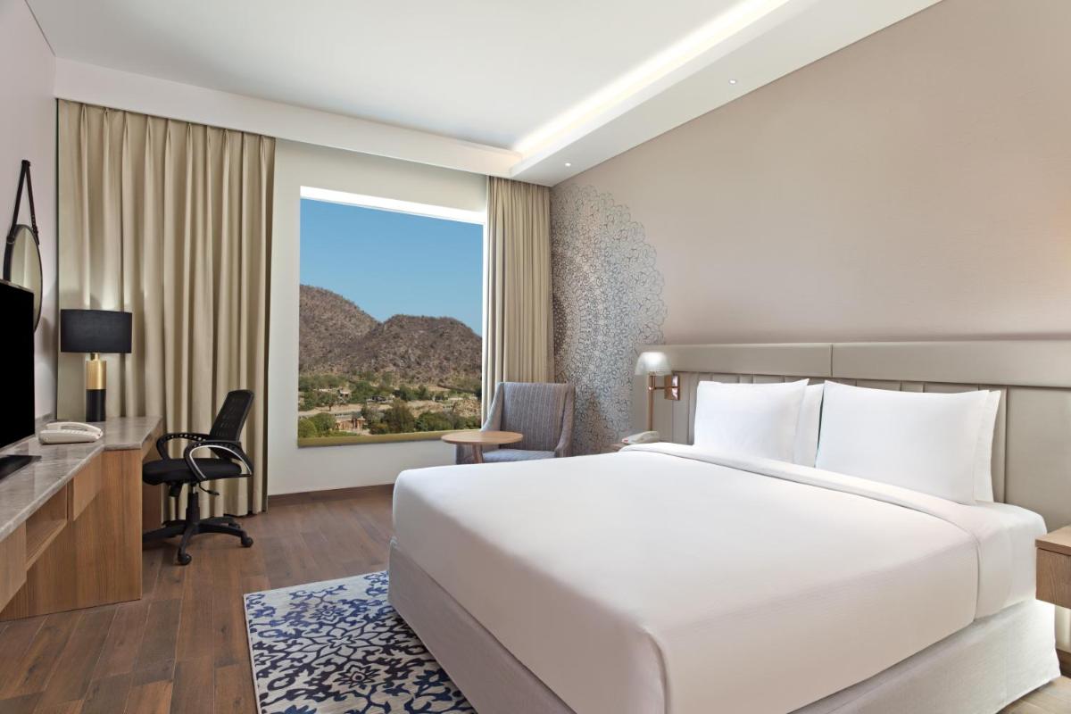 a bedroom with a large white bed and a window at DoubleTree By Hilton Jaipur Amer in Jaipur