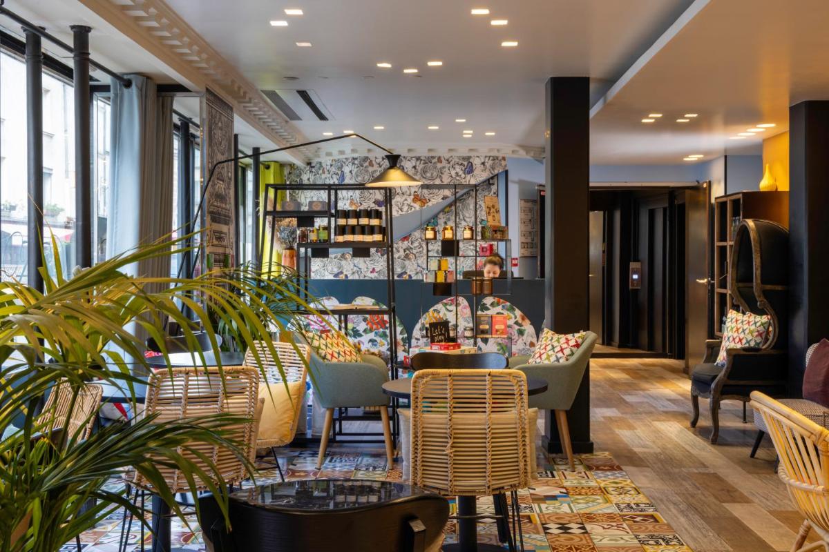 un restaurant avec des chaises, des tables et des fenêtres dans l'établissement Hotel L’Antoine, à Paris