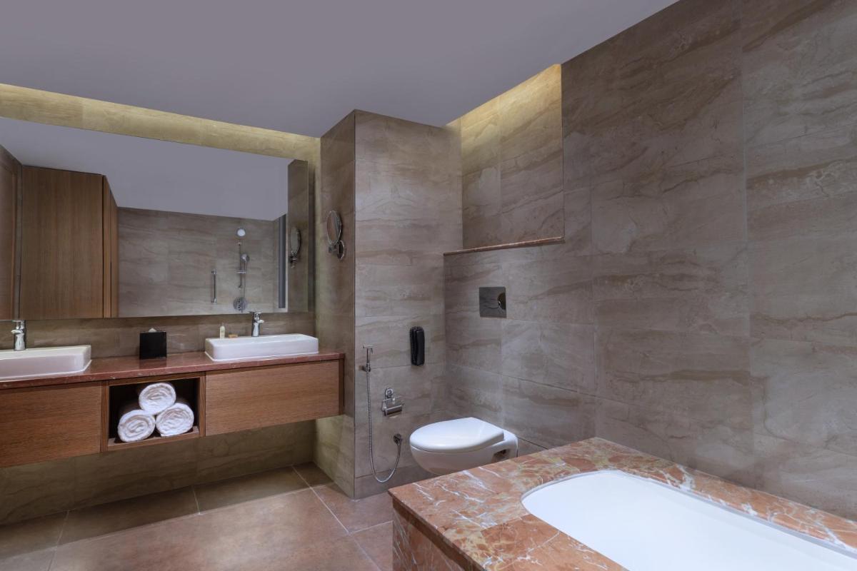 a bathroom with a sink and a toilet and a tub at DoubleTree By Hilton Jaipur Amer in Jaipur