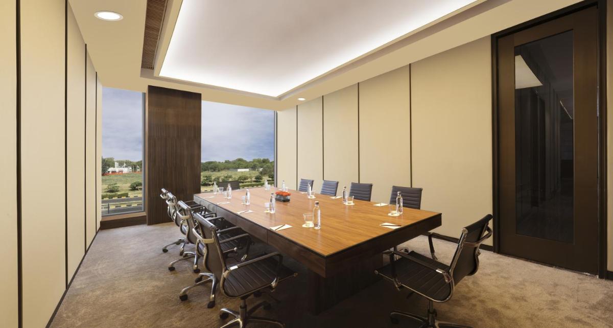 a large conference room with a long table and chairs at Roseate House New Delhi in New Delhi a large conference room with a long table and chairs at Roseate House New Delhi in New Delhi