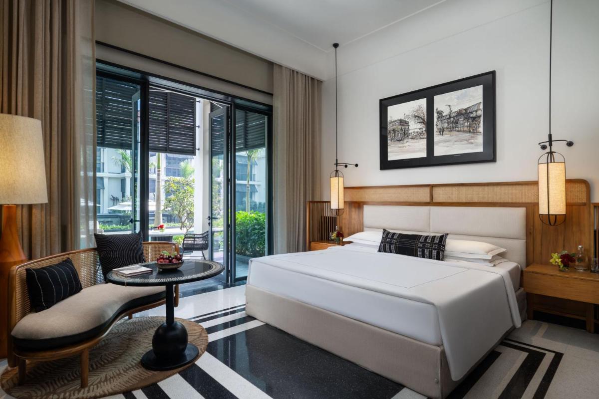 a bedroom with a large white bed and a table at Taj Taal Kutir in Kolkata