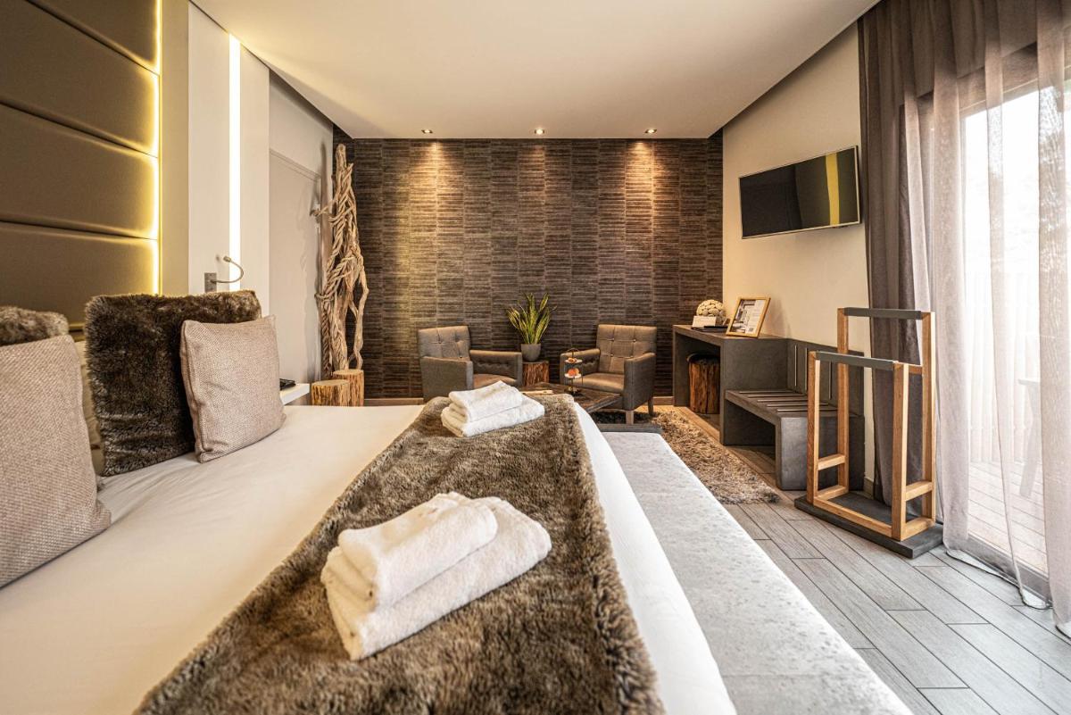 une chambre avec un grand lit et un bureau dans l'établissement Hôtel Le Parc - La Table de Franck Putelat, à Carcassonne