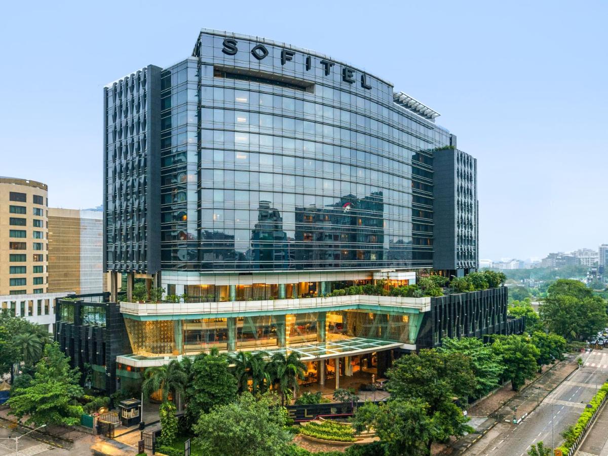 a tall glass building with a sign on it at Sofitel Mumbai BKC in Mumbai