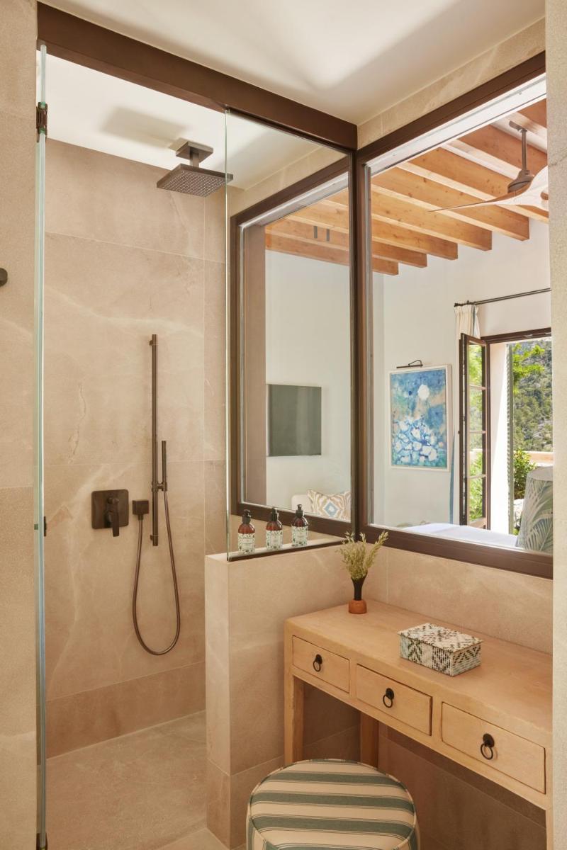 Un baño con ducha, lavabo y espejo. en Son Bunyola Resort and Villas, en Banyalbufar