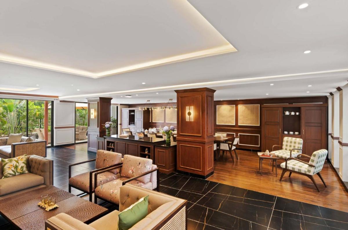 a living room with couches and a kitchen at The Astor - All Suites Hotel Candolim Goa in Candolim a living room with couches and a kitchen at The Astor - All Suites Hotel Candolim Goa in Candolim