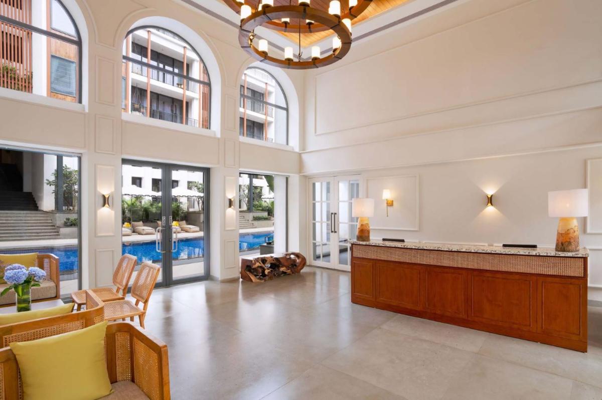 a large lobby with a reception desk and a pool at The Astor - All Suites Hotel Candolim Goa in Candolim a large lobby with a reception desk and a pool at The Astor - All Suites Hotel Candolim Goa in Candolim