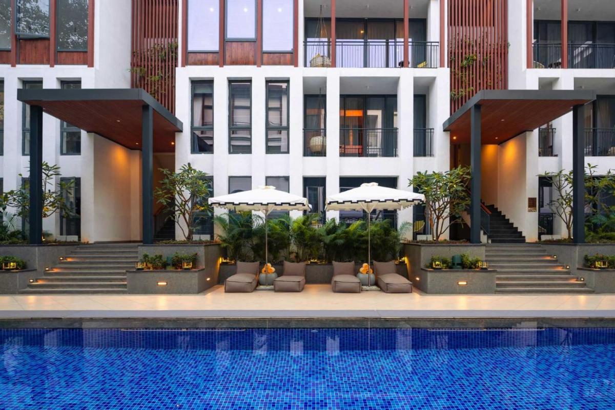 a hotel with a swimming pool in front of a building at The Astor - All Suites Hotel Candolim Goa in Candolim +62 photos a hotel with a swimming pool in front of a building at The Astor - All Suites Hotel Candolim Goa in Candolim +62 photos