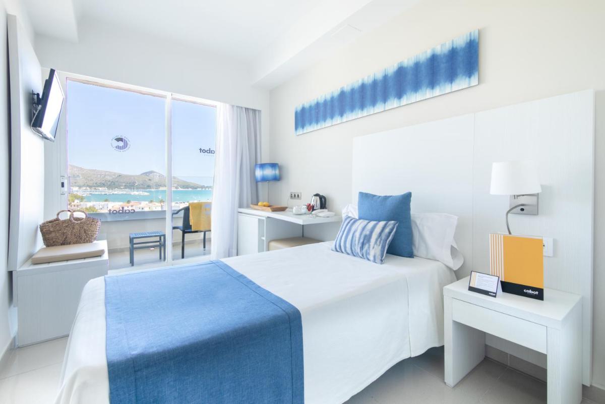 Un dormitorio blanco con una cama y una ventana. en Cabot Pollensa Park Spa, en Puerto Pollensa