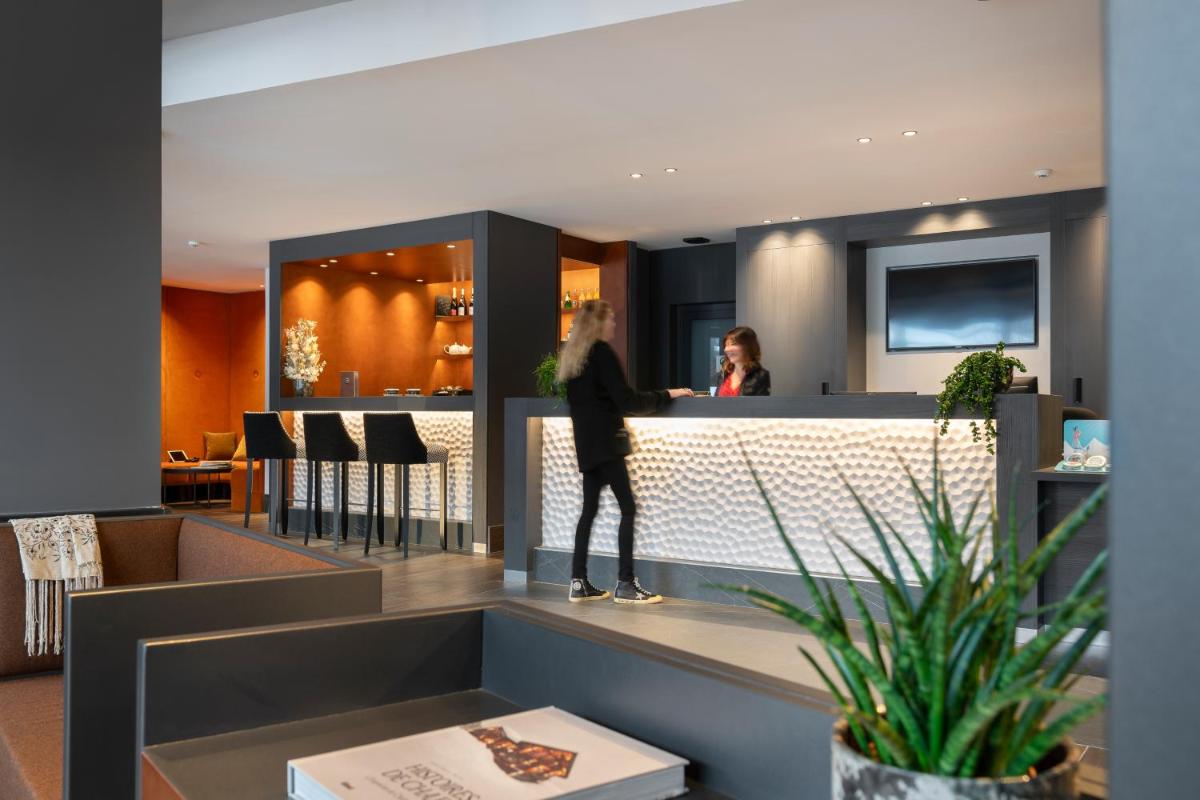 une femme debout au bar d'un restaurant dans l'établissement MGM Hôtels & Résidences - Résidence Chalets Laska, aux Contamines-Montjoie