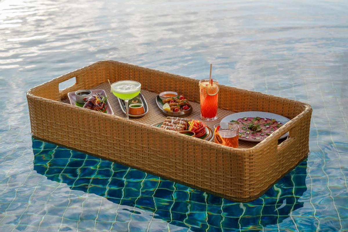 a tray of food and drinks in a basket in the water at The Westin Resort & Spa Himalayas in Rishīkesh