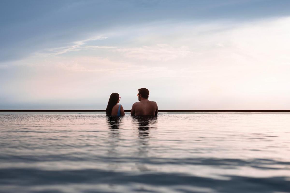 a man and a woman sitting in the water at The Westin Resort & Spa Himalayas in Rishīkesh