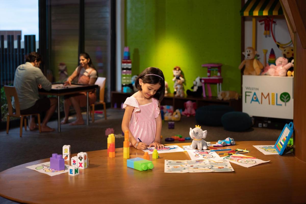 a little girl playing with toys on a table at The Westin Resort & Spa Himalayas in Rishīkesh