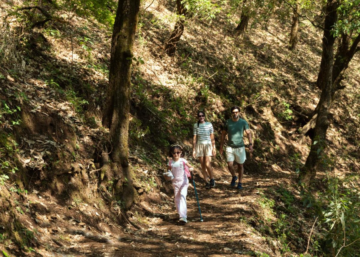 two adults and a little girl walking down a trail at The Westin Resort & Spa Himalayas in Rishīkesh