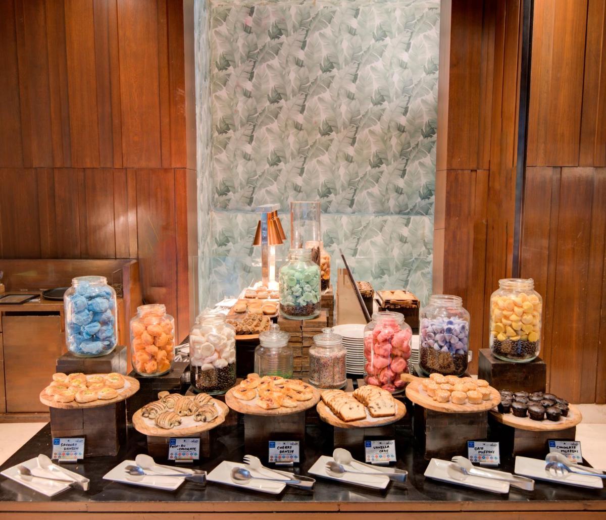 a table filled with different types of pastries and desserts at Hyatt Ahmedabad in Ahmedabad
