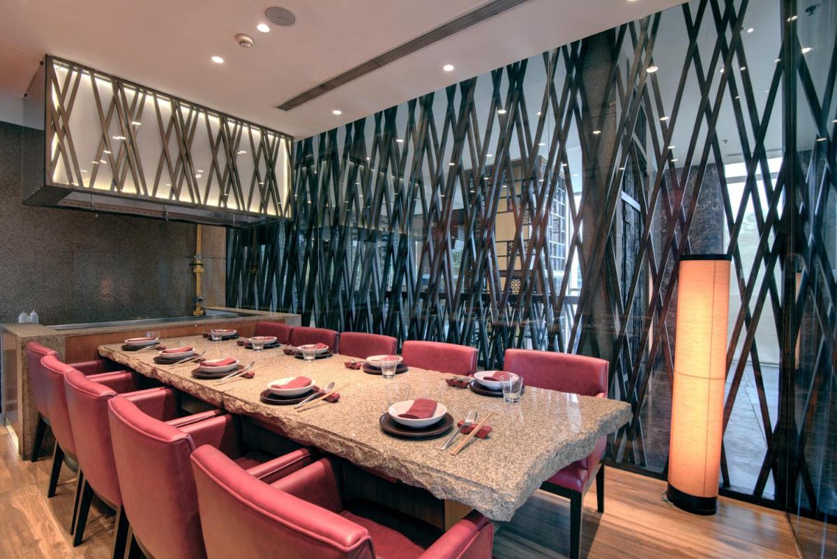 a dining room with a long table and red chairs at Hyatt Ahmedabad in Ahmedabad